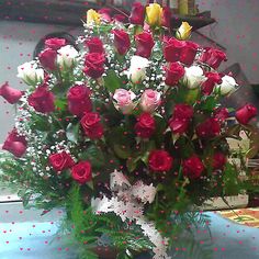 a vase filled with lots of red and white roses