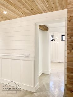 an empty room with white walls and wood paneling on the ceiling is seen in this image