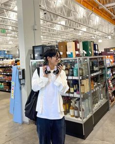 a man standing in front of a store holding a camera