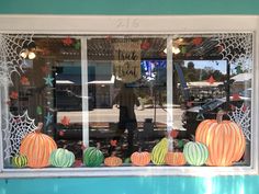 a store front window with pumpkins and stars on it