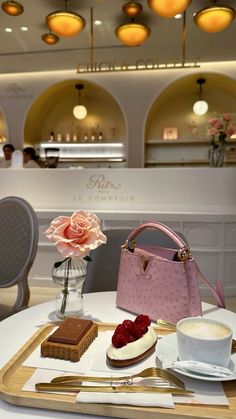 a tray with cake, cupcakes and a pink purse on it