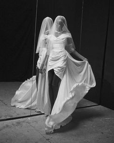 two women in white dresses and veils are walking