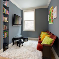 a living room filled with furniture and a flat screen tv mounted to the side of a wall