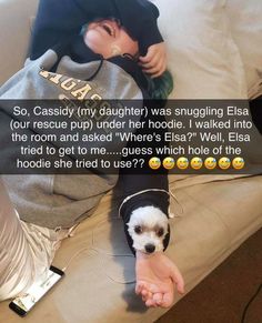 a woman laying on top of a couch next to a small dog wearing headphones