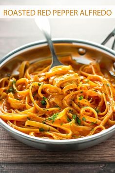 a bowl filled with pasta and garnished with parsley on a wooden table