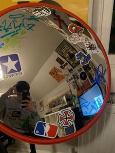 a person taking a selfie in a mirror with stickers all over the frame