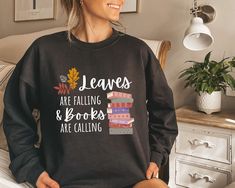 "Grab your favorite book and a warm beverage and bundle up in this warm Fall Heavy Crewneck Sweater. This classic crewneck sweater reads, \"Leaves are falling & Books are falling.\" Add this cozy sweater to this year's Autumn wardrobe! 🍂 Unisex Sweater 🍂 50% Cotton 50% Polyester  🍂 Fleece 🍂 Medium- Heavy fabric 🍂 Runs true to size 🍂 Loose fit 🍂 Model is wearing a size Large ❤ This product is made especially for you as soon as you place an order, which is why it takes us a bit longer to deliver it to you. Making products on demand instead of in bulk helps reduce overproduction, so thank you for making thoughtful purchasing decisions! :) ❤ Shipping & Returns: We're happy to offer a refund if there is any damage to an order. This can include manufacturing errors, items arriving with ho Pumpkin Sweater, Cozy Sweaters Autumn, Fall Sweaters For Women, Autumn Sweater, Fallen Book, Autumn Wardrobe, Fall Hoodies, Fall Sweater, Book Worm