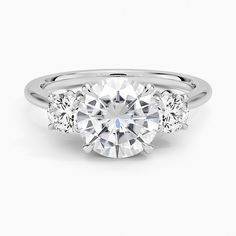 three stone engagement ring in white gold with diamonds on the sides and round brilliant cut center