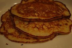 three pancakes on a white plate stacked high