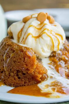 a piece of cake on a plate with ice cream and caramel drizzle