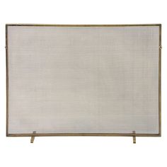 a white and gold fireplace screen with metal bars on each side, against a white background