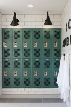 the lockers are lined up against the wall with towels hanging in front of them