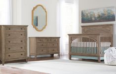 a baby's room with a chair, dresser and crib