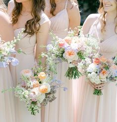 the bridesmaids are holding their bouquets together