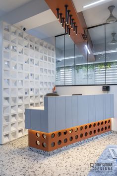 the interior of a modern office with an orange and grey counter top, white shelvings, and large mirrors