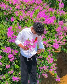 a man standing in front of purple flowers