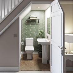 an open door leading to a bathroom with green tiles on the walls and flooring