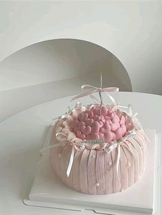 a cake with pink and white frosting in a basket on top of a table