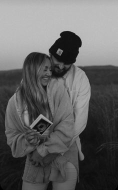 a man and woman standing next to each other in a field