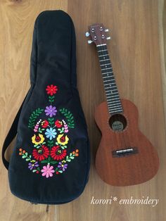 an ukulele and guitar case sitting on a wooden floor next to each other