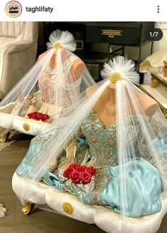 two mannequins dressed in wedding dresses with veils and roses on them