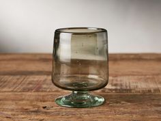 an empty glass sitting on top of a wooden table