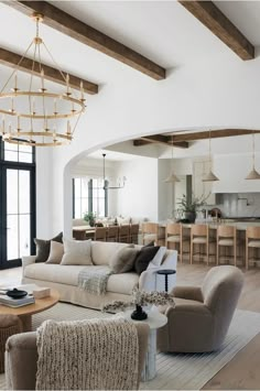 a living room filled with furniture and a chandelier hanging over the top of it