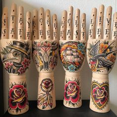 four wooden hand puppets with designs on them