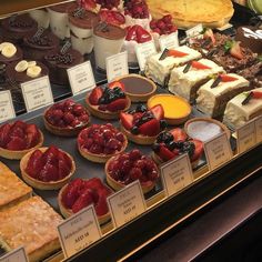 a display case filled with lots of different types of desserts and pastries on top of each other