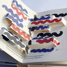 an open book with different colored paper mustaches on it's pages and the title in red, white, and blue