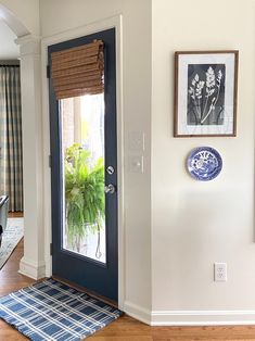 a blue and white rug in front of a door with pictures on the wall next to it