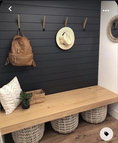 a wooden bench sitting next to a wall filled with hats and purses on top of it