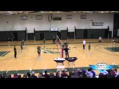 a group of people standing on top of a basketball court