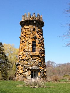 an old stone tower sitting on top of a lush green field