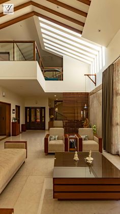 a living room filled with lots of furniture next to a tall wooden ceiling above a glass top coffee table