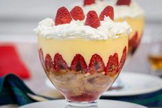 two desserts with strawberries and whipped cream on top are served in small glasses