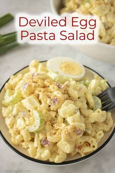 an egg pasta salad is served in a bowl with a fork and another side dish