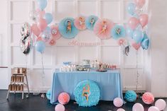 a table with balloons and decorations for a little mermaid birthday party in blue, pink and white