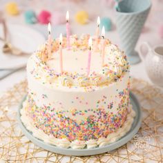 a birthday cake with white frosting and multicolored sprinkles on it