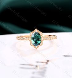 an emerald colored ring with diamonds on top