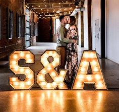 a man and woman standing next to the letters s & a