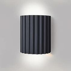 a wall mounted light on the side of a white wall