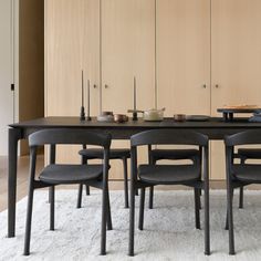 a dining room table with four chairs and a bowl on the center piece in front of it