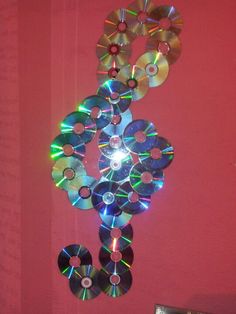 a clock made out of cd's hanging on the wall