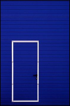 an open door is shown in front of a bright blue wall with vertical lines on it