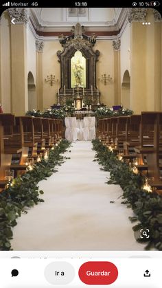 the aisle is decorated with greenery and candles