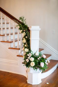 the flowers are on the bannister at the bottom of the stairs