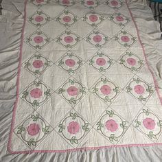 a white quilt with pink flowers on it