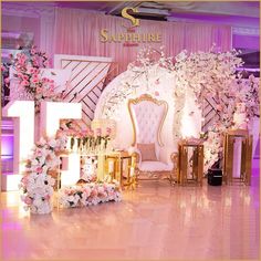 the stage is decorated with pink flowers and gold furniture for an elegant wedding or special event