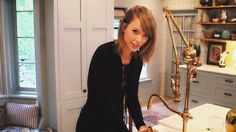 a woman standing next to a kitchen counter with a golden faucet on it